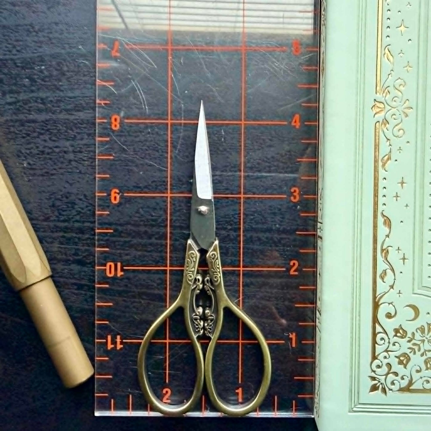Decorative scissors on a cutting mat with a ruler