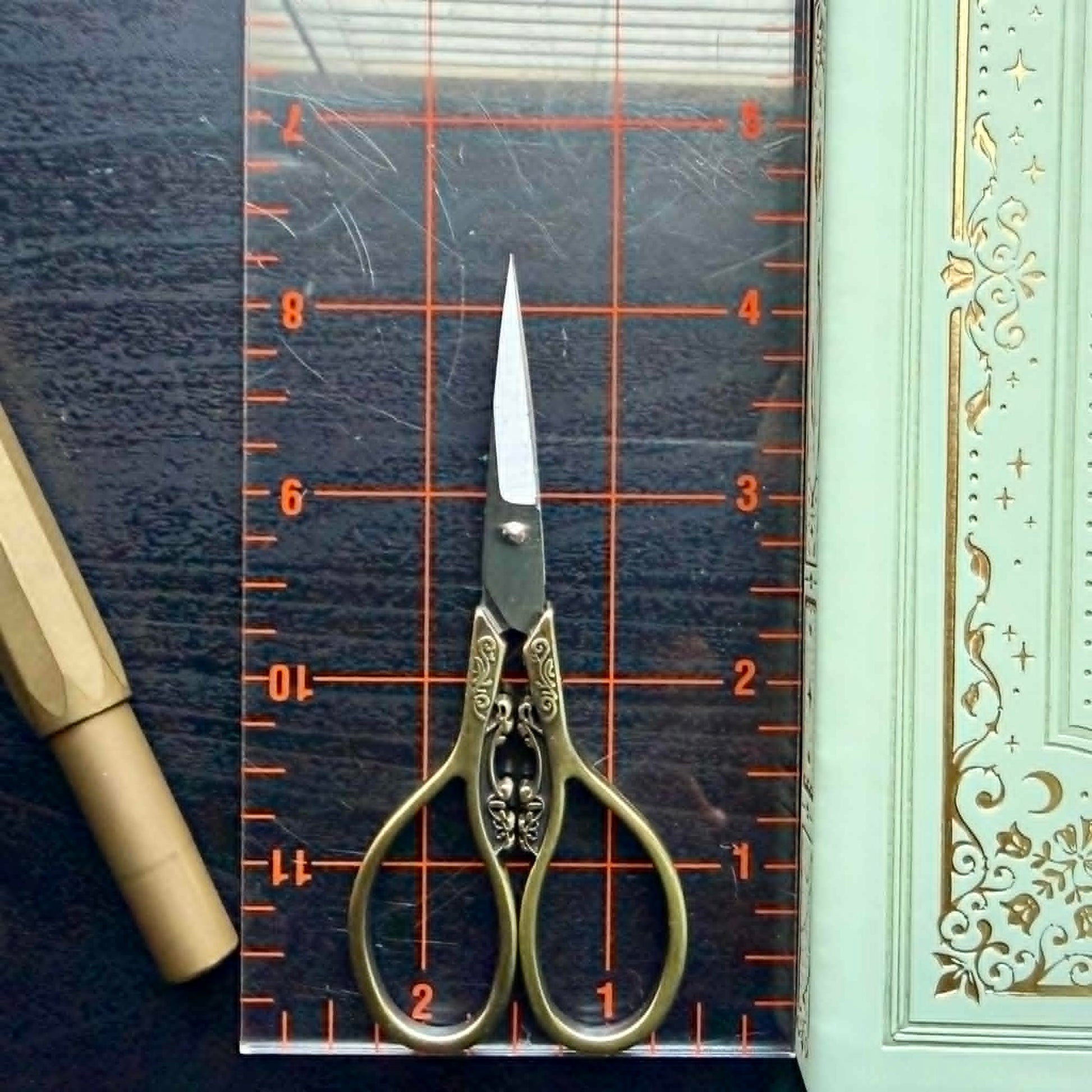 Decorative scissors on a cutting mat with a ruler