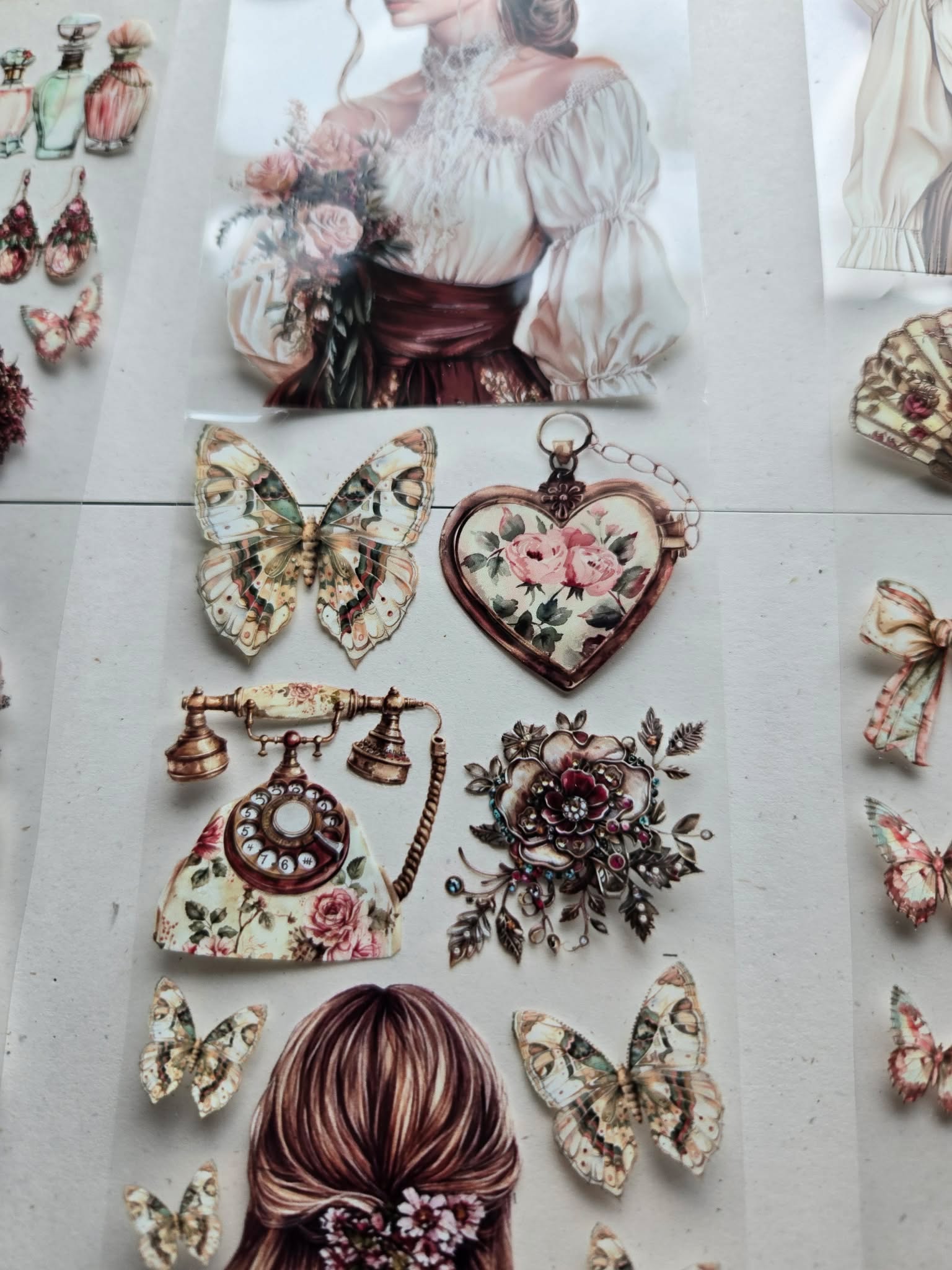Vintage-style decorative elements including a woman's portrait, butterflies, and floral heart on a textured surface.