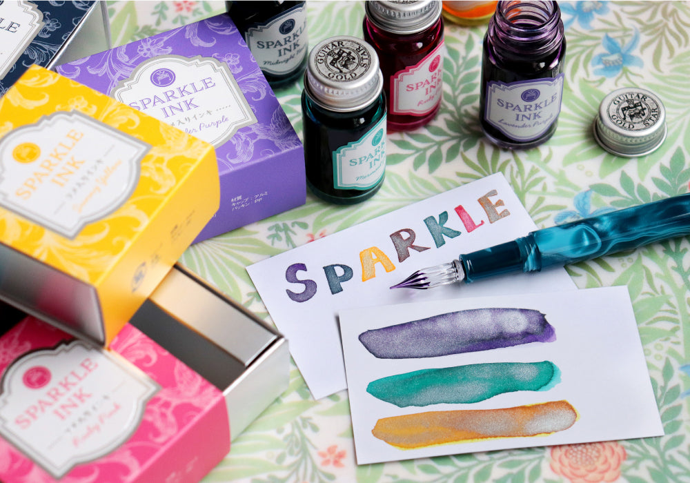 Teranishi Guitar Sparkle Ink bottles, colorful boxes, glass dip pen, and shimmering ink swatches